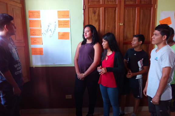 Grupo de j�venes frente a un cartel con propuestas de actividades para la juventud