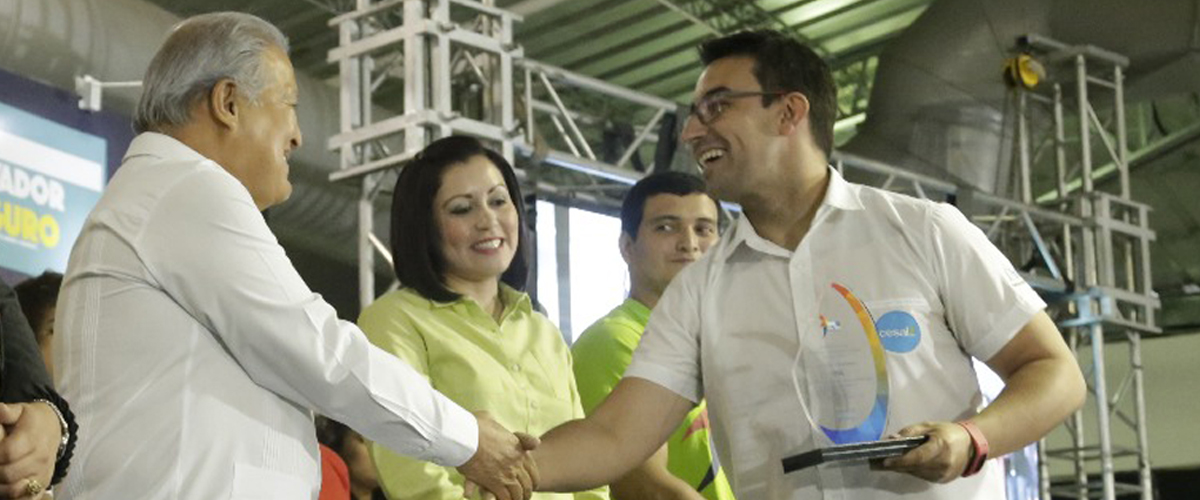 un hombre entrega una placa de reconocimiento a otro hombre