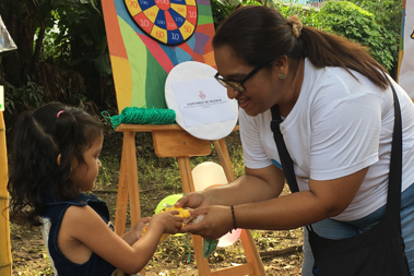 Una joven entrega un premio en las manos a una ni�a